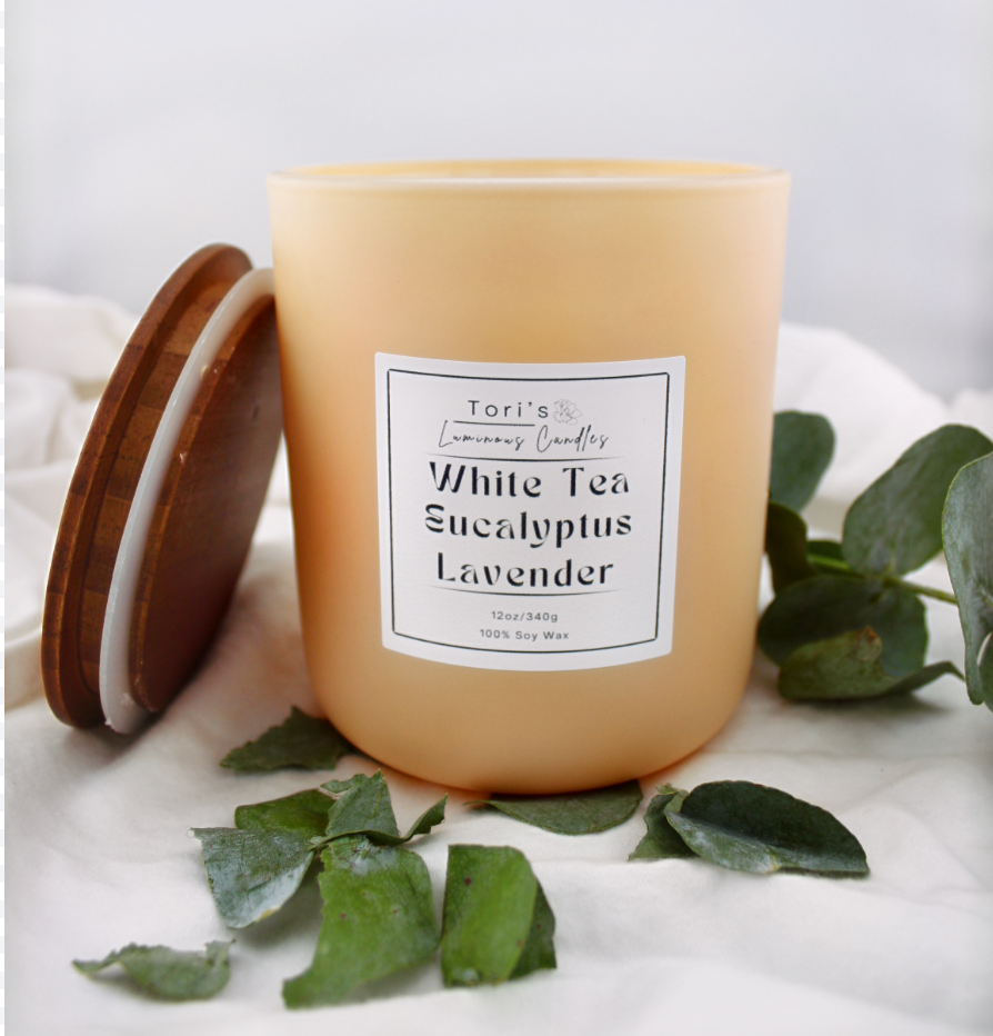 White tea, eucalyptus, and lavender candle in matte sage 8 oz and matte peach 12 oz jars, styled in a peaceful setting with soft lighting—ideal for spa-inspired relaxation at home or in a salon.