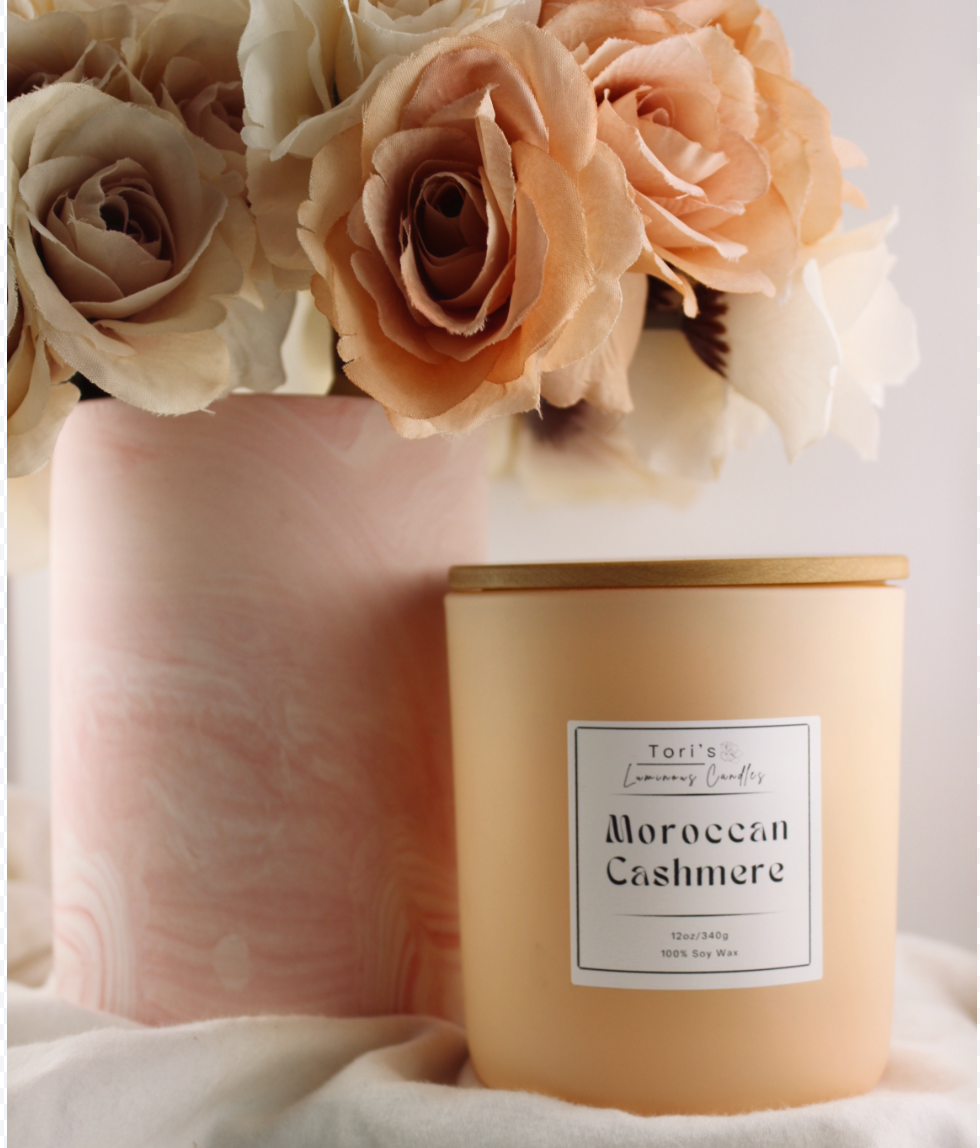 Moroccan Cashmere candle in a 12 oz matte peach jar and 8 oz copper tin, styled in an elegant, minimalist space that reflects the essence of quiet luxury.
