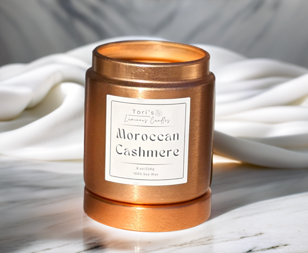 Moroccan Cashmere candle in a 12 oz matte peach jar and 8 oz copper tin, styled in an elegant, minimalist space that reflects the essence of quiet luxury.