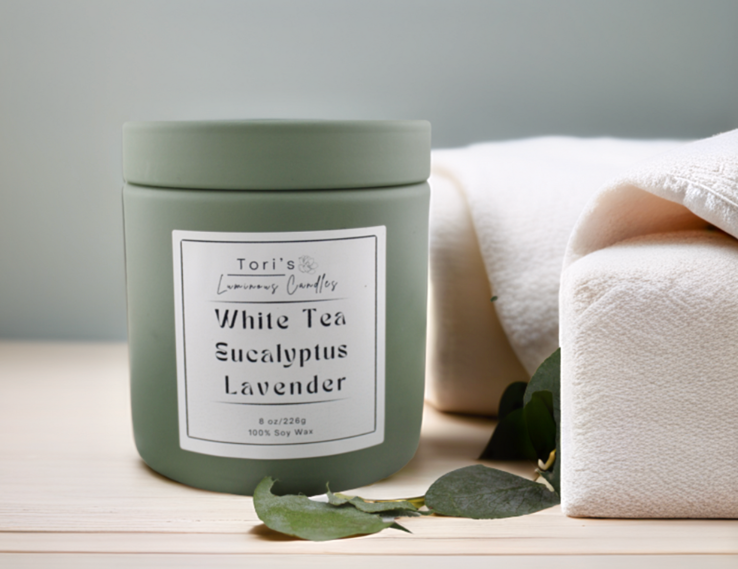 White tea, eucalyptus, and lavender candle in matte sage 8 oz and matte peach 12 oz jars, styled in a peaceful setting with soft lighting—ideal for spa-inspired relaxation at home or in a salon.