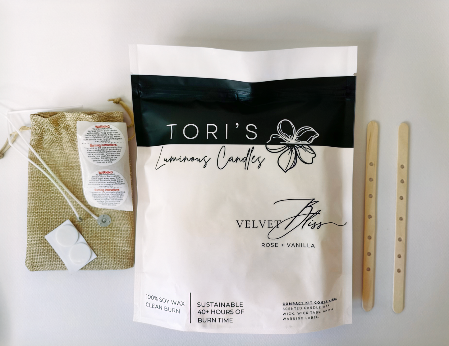 Flat lay of the Rewick & Chill refill kit featuring two cotton wicks, wick tabs, and a sealed pouch of pre-scented soy wax in the Peony + Vanilla scent. Surrounded by soft pink peony petals and vanilla pods on a neutral fabric background, evoking a clean, dreamy summer vibe.