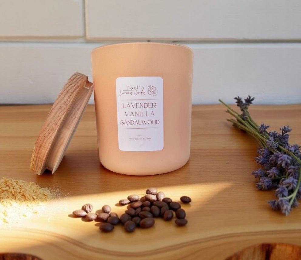 12oz Lavender, Vanilla & Sandalwood candle in a matte cream jar, surrounded by soft home décor accents, evoking a calm and cozy atmosphere.