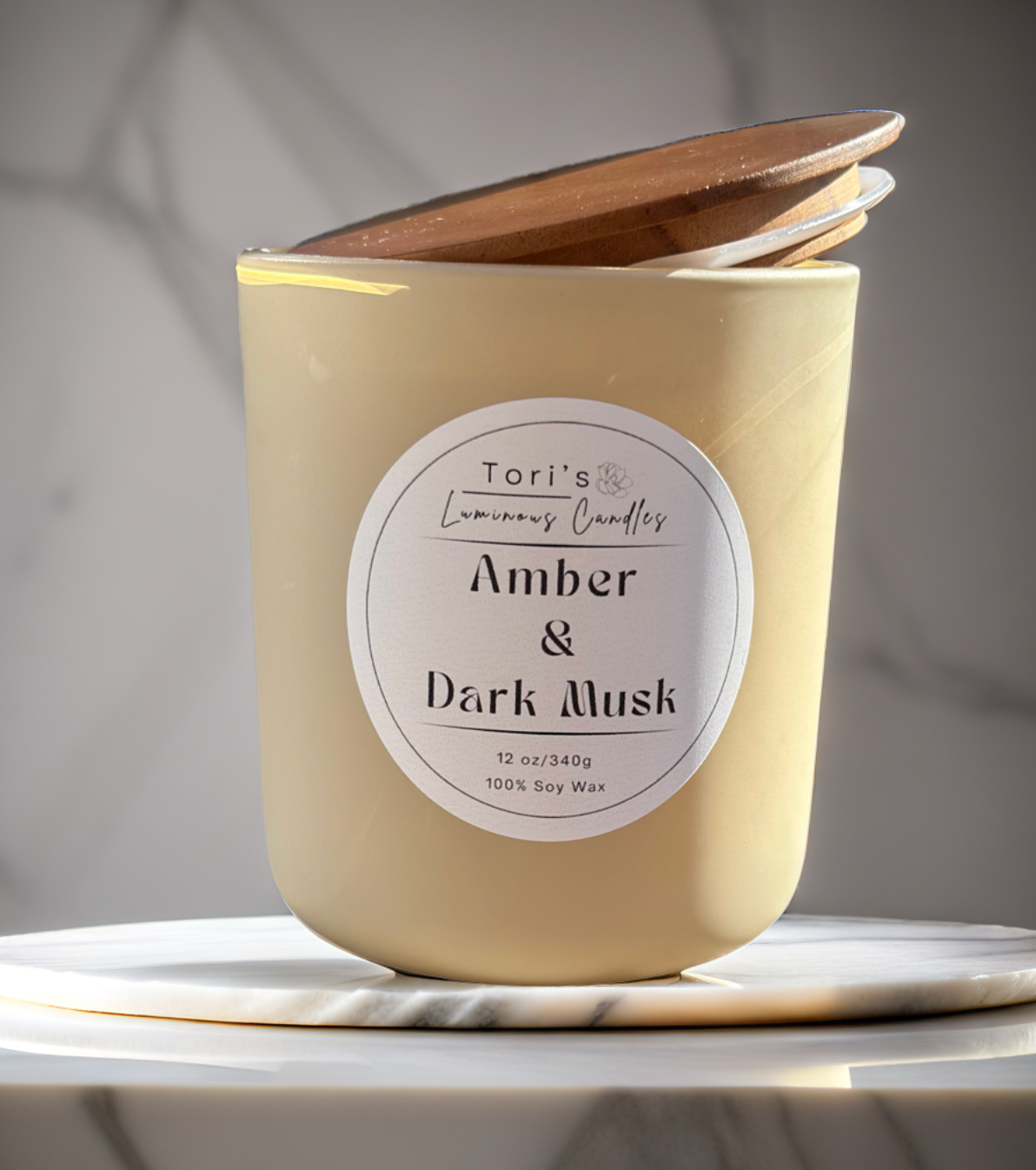Amber & Dark Musk candle in a frosted amber 8 oz jar and matte cream 12 oz jar, styled on a neutral-toned surface with soft lighting, showcasing the elegant vessels and cozy home décor vibes.
