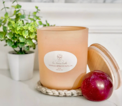 Floral and fruity candle in 8 oz matte sage and 12 oz matte peach jars, styled in a cozy, elegant space—capturing year-round charm and a timeless, classy feel.