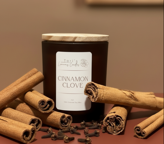 cinnamon and clove soy candle styled with cinnamon sticks, whole cloves, and warm neutral textures, creating a cozy, spiced holiday atmosphere.
